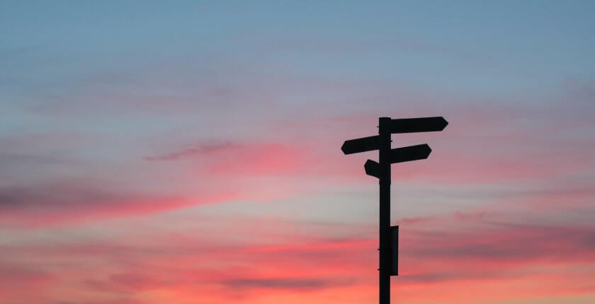 Sunset with road signs symbolising a decision