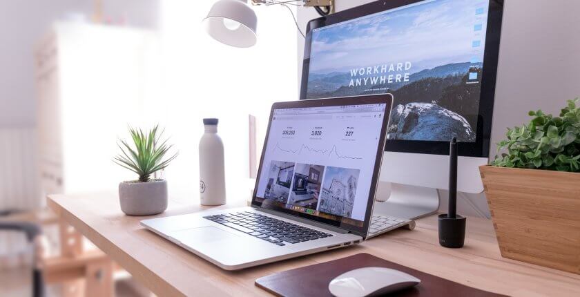 Picture of a laptop and computer at a desk